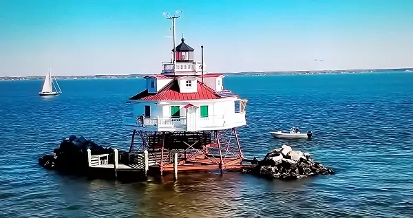 A lighthouse sitting on top of a body of water.