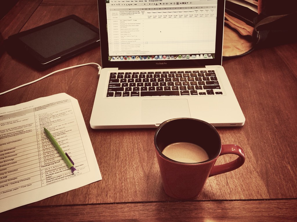 A cup of coffee is next to an open laptop.